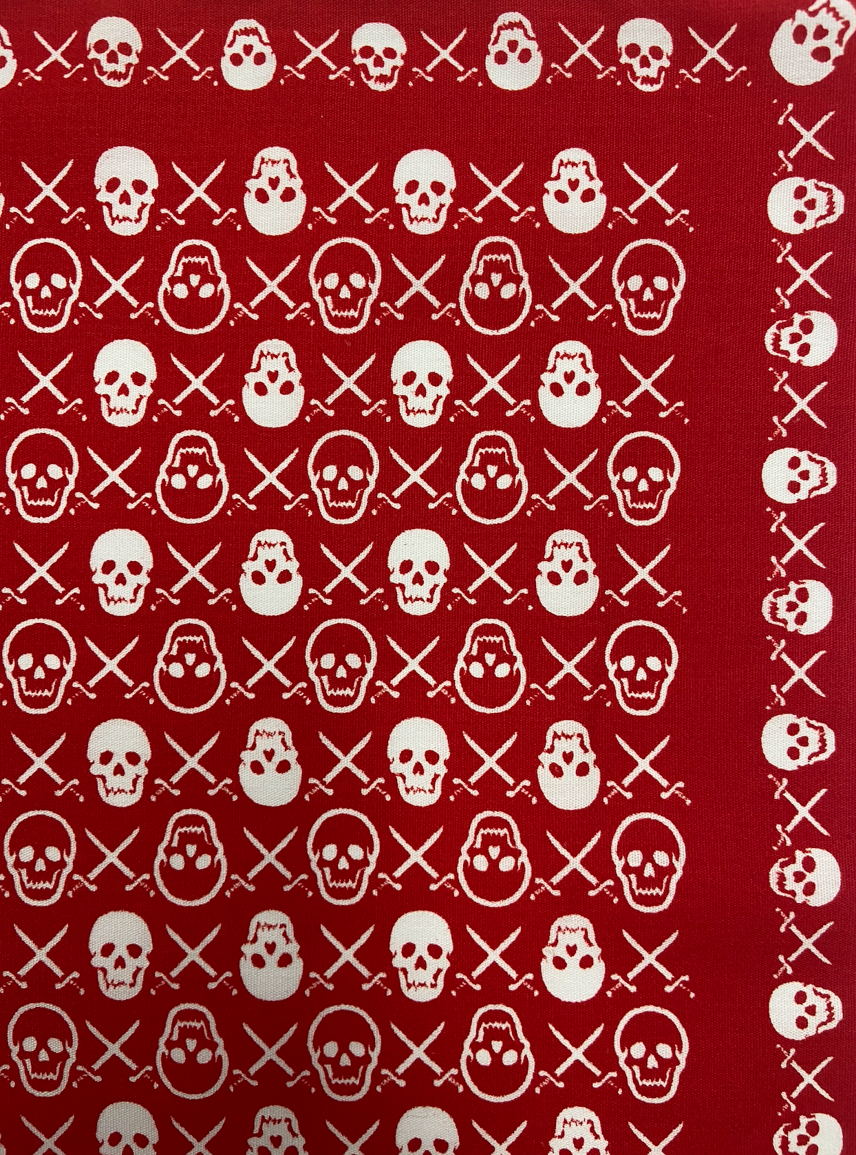 red bandana with small skulls and crossbones repeating pattern